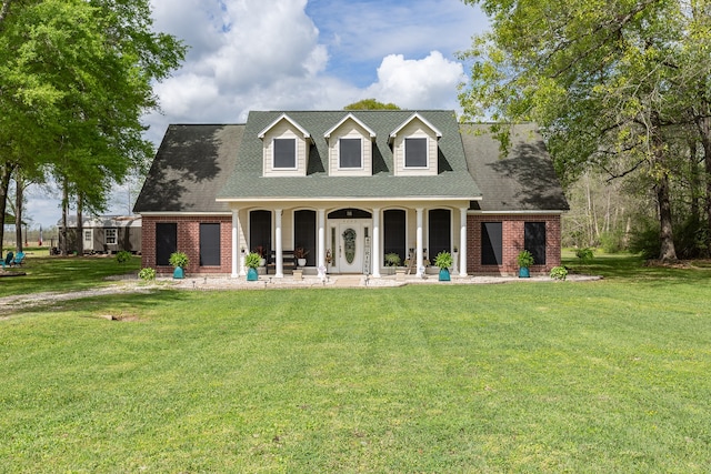 rear view of house with covered porch and a yard