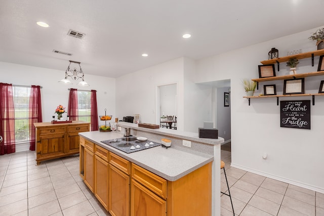 kitchen featuring a kitchen bar, black electric stovetop, light tile patterned flooring, a kitchen island, and pendant lighting