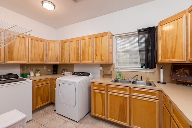 laundry room featuring washer and clothes dryer, cabinets, sink, and light tile patterned floors