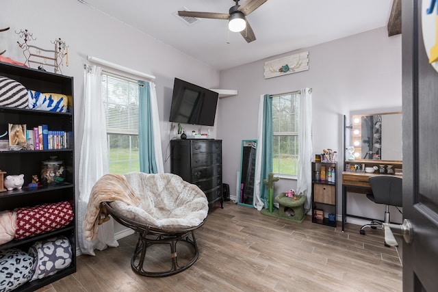 living area featuring ceiling fan and light hardwood / wood-style flooring