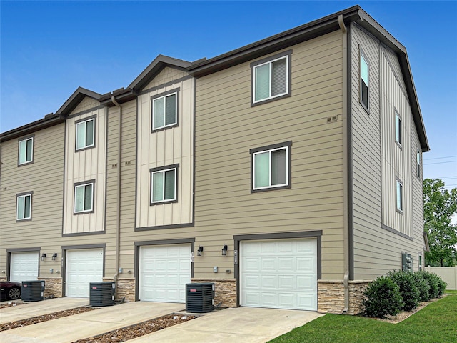 view of front of property with a garage and central AC unit