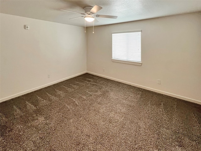 unfurnished room with ceiling fan and dark carpet