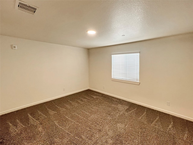 carpeted spare room with a textured ceiling