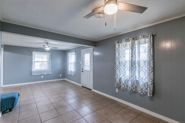 tiled entryway featuring ceiling fan, a textured ceiling, and crown molding