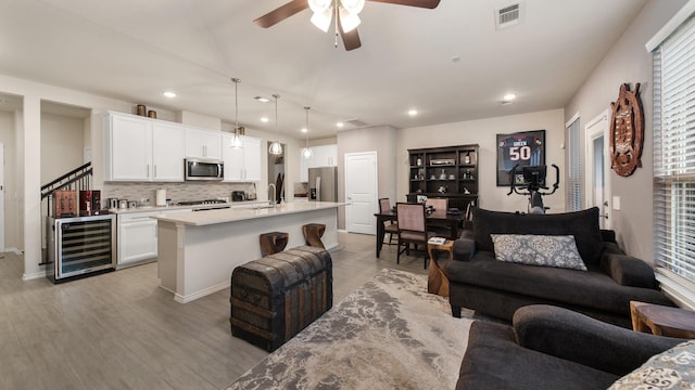 10507 Marston Vineyard Dr, Houston, TX 77025 - living area featuring wine cooler, ceiling fan, recessed lighting, light wood-type flooring, and baseboards