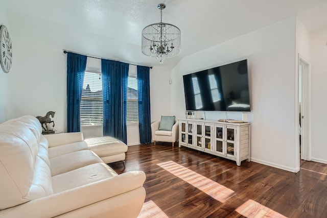 living room with dark hardwood / wood-style flooring, an inviting chandelier, and vaulted ceiling