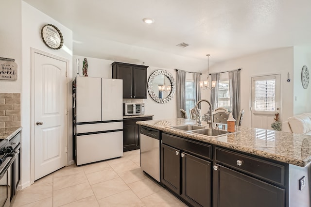 kitchen with white refrigerator, decorative backsplash, sink, an island with sink, and dishwasher