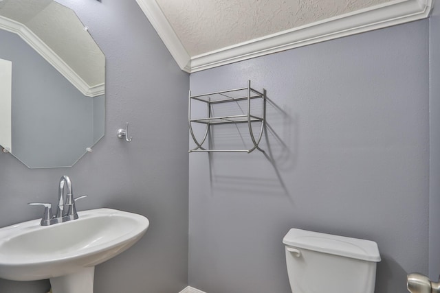 bathroom featuring a sink, toilet, and ornamental molding