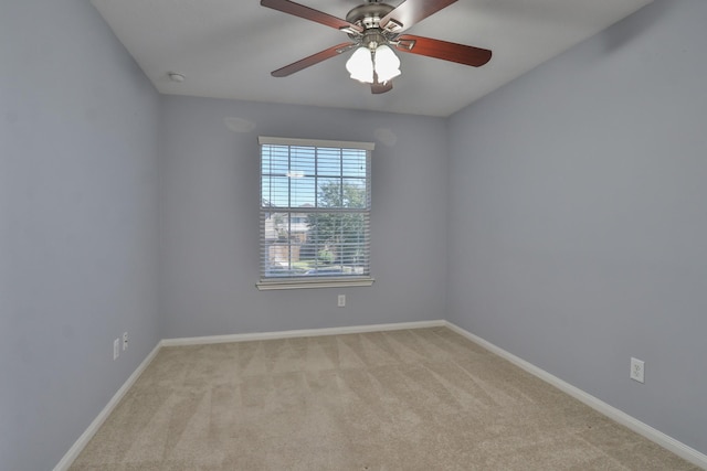 empty room featuring light colored carpet, baseboards, and ceiling fan