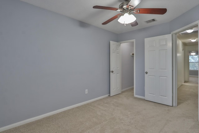 unfurnished bedroom featuring ceiling fan, baseboards, visible vents, and light carpet