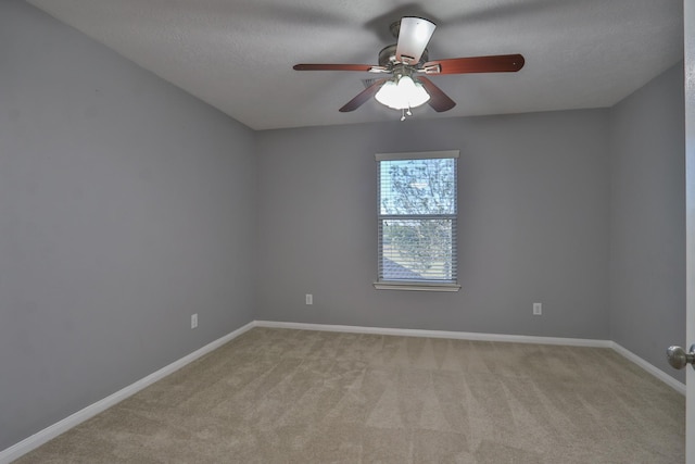 unfurnished room with a textured ceiling, light colored carpet, baseboards, and ceiling fan