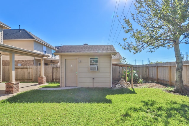 rear view of property with an outdoor structure and a yard