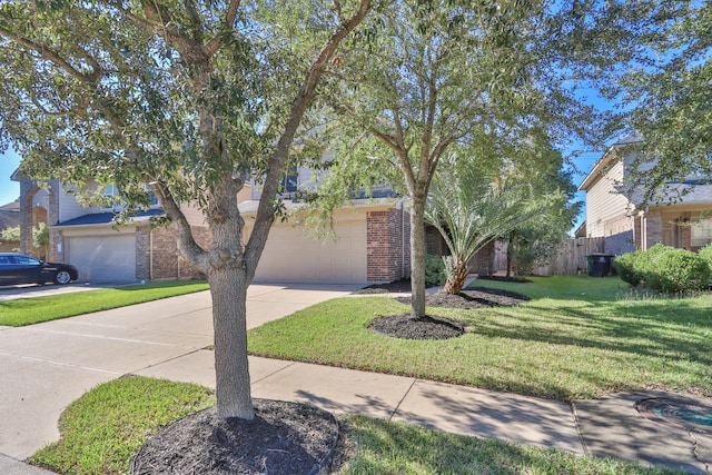 view of front of house with a front lawn, concrete driveway, fence, and brick siding