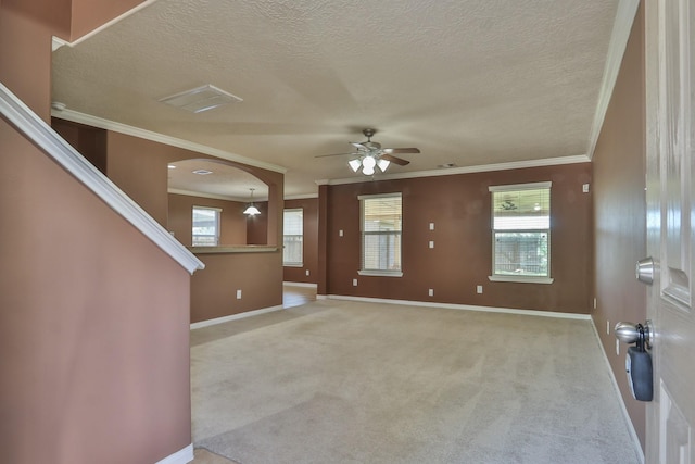 unfurnished living room featuring carpet flooring, baseboards, crown molding, and ceiling fan