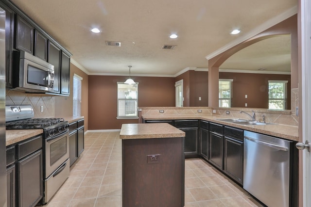 kitchen featuring visible vents, a center island, light tile patterned flooring, stainless steel appliances, and a sink