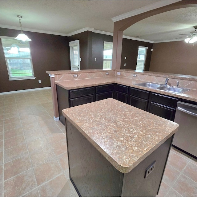 kitchen featuring stainless steel dishwasher, light countertops, ornamental molding, and a sink