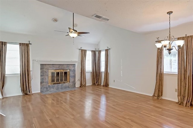 unfurnished living room with a wealth of natural light, light hardwood / wood-style floors, and vaulted ceiling