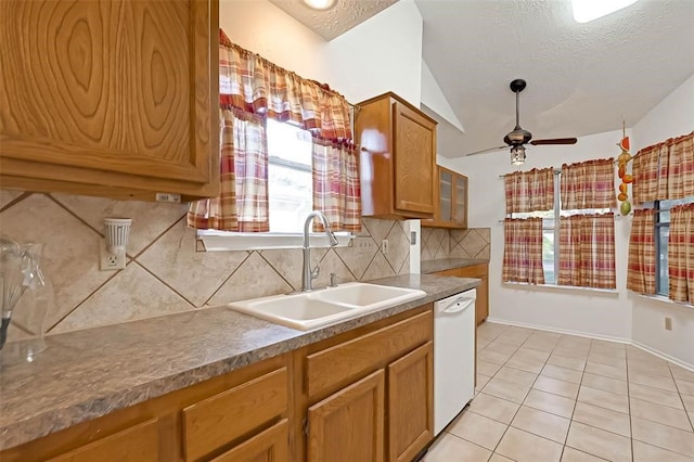 kitchen featuring light tile patterned flooring, sink, a textured ceiling, backsplash, and dishwasher