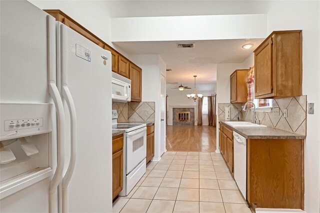 kitchen featuring decorative light fixtures, sink, white appliances, and backsplash