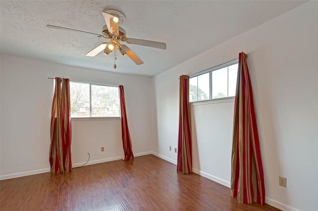 unfurnished room featuring a textured ceiling, dark hardwood / wood-style flooring, and ceiling fan