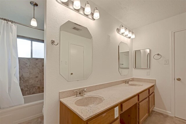 bathroom with shower / bath combo, vanity, a textured ceiling, and tile patterned floors