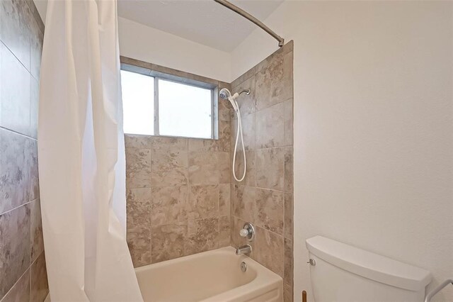 bathroom with shower / tub combo with curtain and toilet