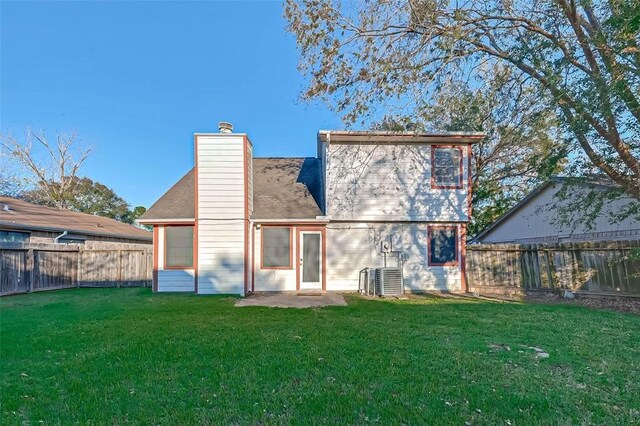 rear view of house with central AC unit, a patio, and a yard