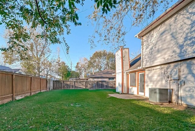 view of yard with central AC unit and a patio