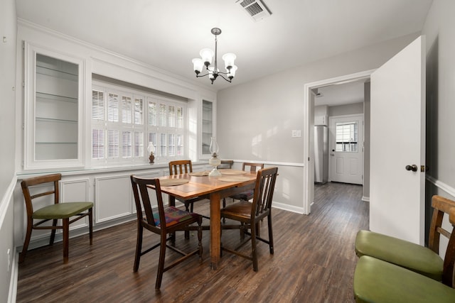 dining area featuring dark hardwood / wood-style flooring and an inviting chandelier