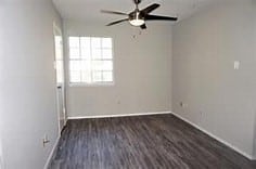 empty room with ceiling fan and dark hardwood / wood-style floors