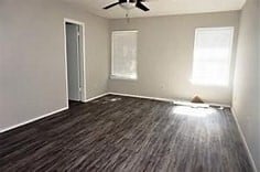 spare room with dark wood-type flooring and ceiling fan