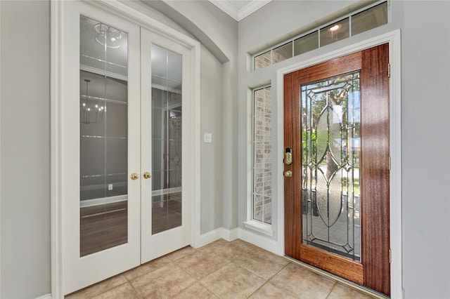 entryway featuring french doors, light tile patterned floors, and crown molding