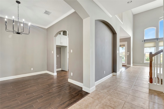 interior space with hardwood / wood-style floors, an inviting chandelier, and crown molding