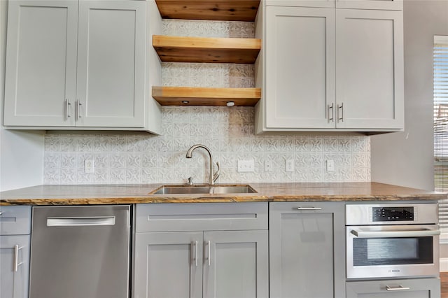 kitchen featuring stone countertops, sink, appliances with stainless steel finishes, and tasteful backsplash