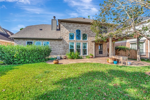 back of house featuring a lawn and a patio area