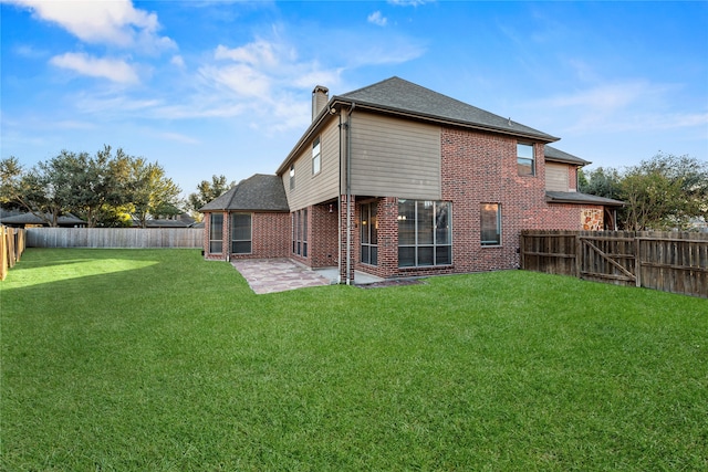 rear view of house with a patio and a lawn