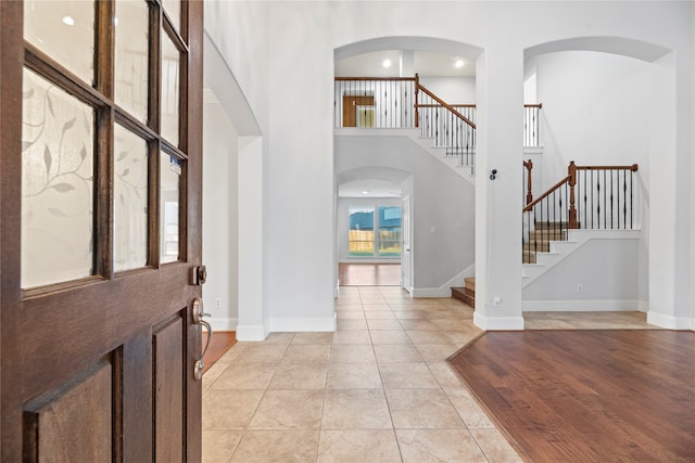 foyer with a high ceiling and light hardwood / wood-style flooring