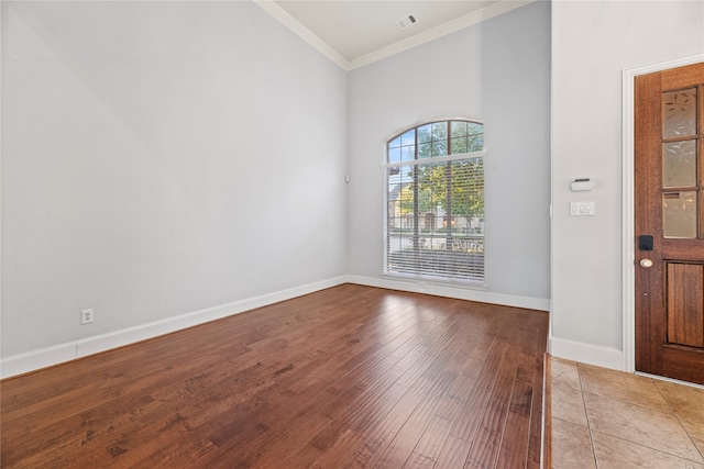 foyer entrance with light hardwood / wood-style floors and ornamental molding