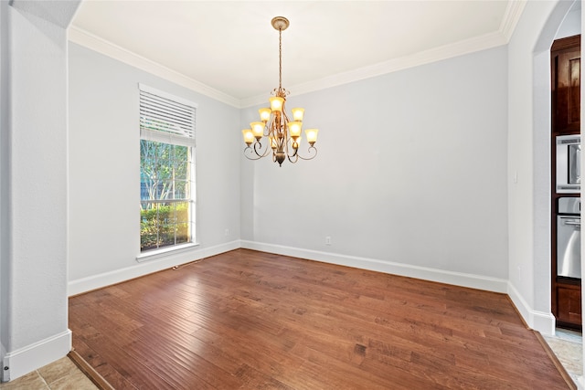 unfurnished room featuring a chandelier, hardwood / wood-style floors, and ornamental molding