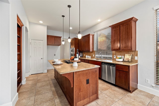 kitchen with decorative backsplash, appliances with stainless steel finishes, sink, decorative light fixtures, and a center island