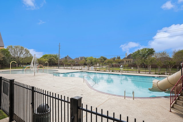 view of pool with a water slide and a patio