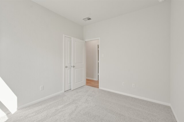 unfurnished room with light colored carpet