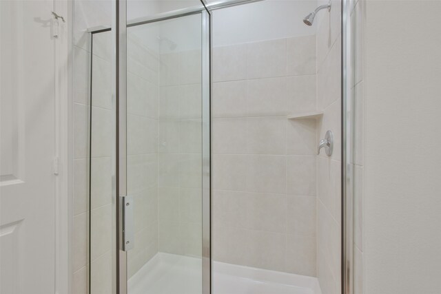 bathroom featuring a shower with door