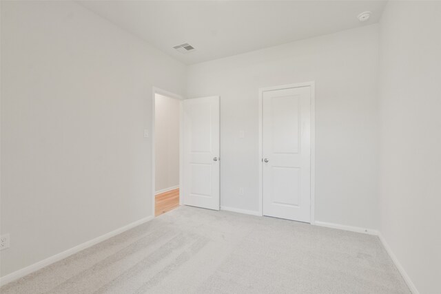 unfurnished bedroom featuring light carpet