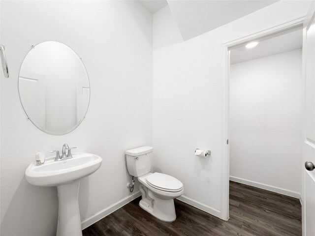 bathroom featuring hardwood / wood-style flooring, toilet, and sink