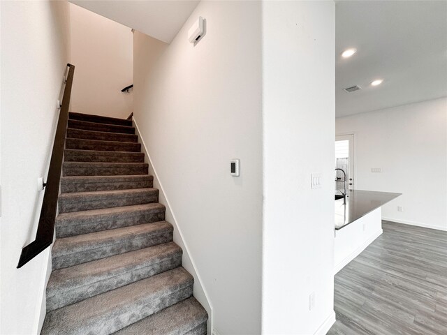 stairs with hardwood / wood-style floors