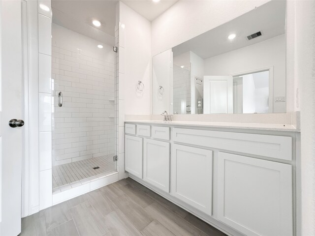 bathroom featuring vanity and an enclosed shower