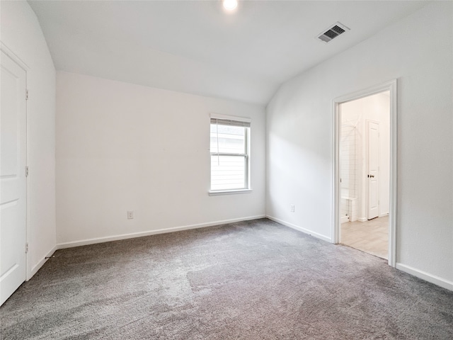 unfurnished room featuring vaulted ceiling and carpet