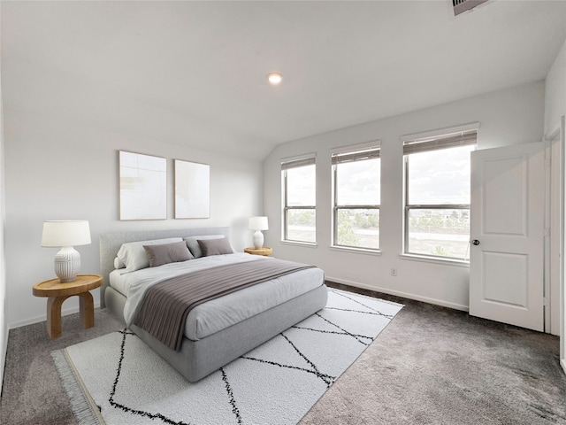 bedroom with lofted ceiling and dark colored carpet