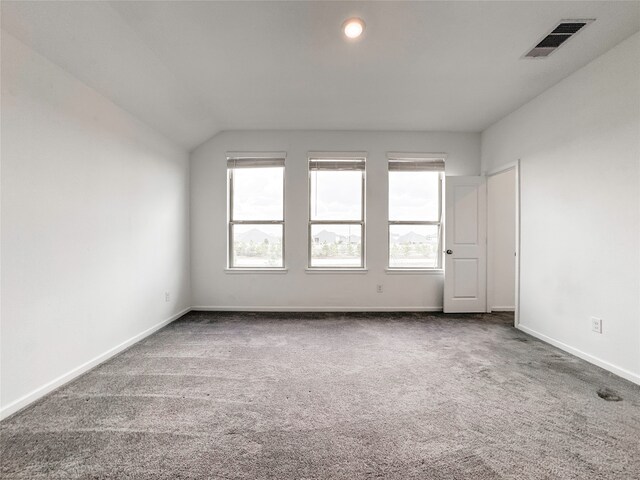 carpeted spare room featuring lofted ceiling